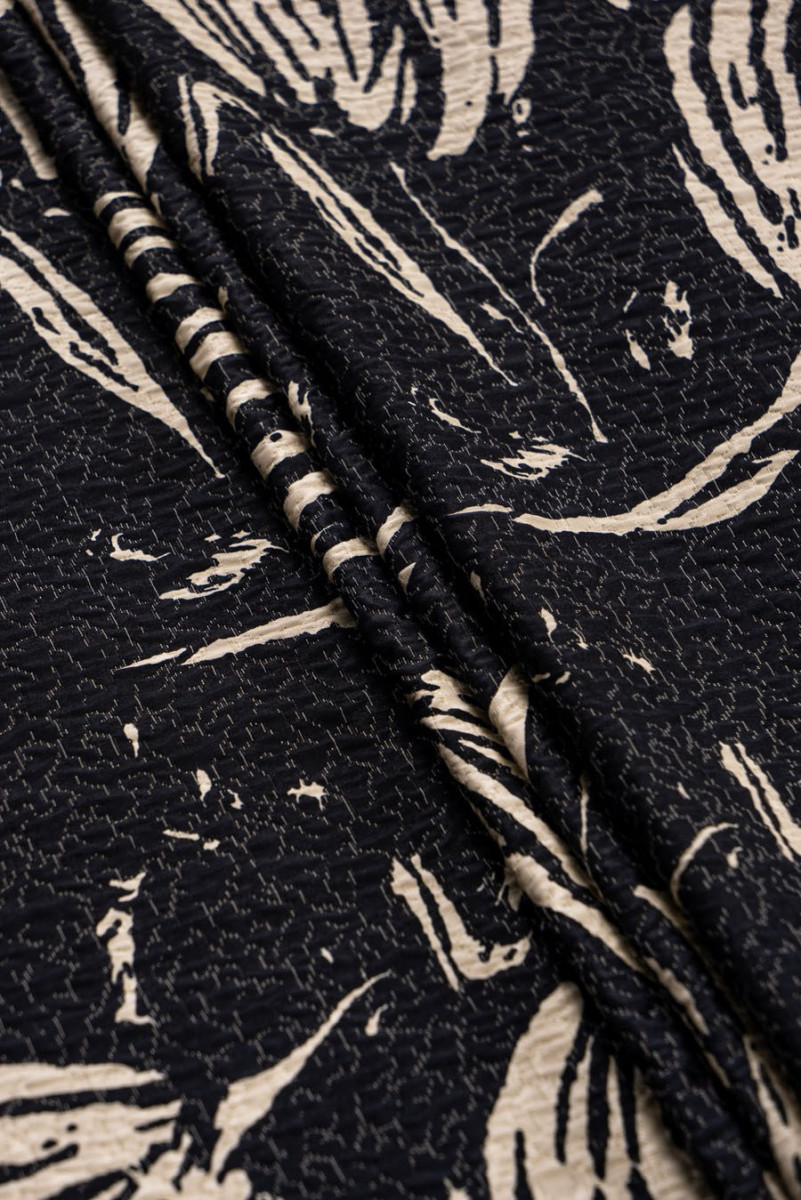 Krokaina auduma melnas lapas uz smilškrāsas